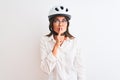 Beautiful businesswoman wearing glasses and bike helmet over isolated white background asking to be quiet with finger on lips Royalty Free Stock Photo
