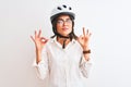 Beautiful businesswoman wearing glasses and bike helmet over isolated white background relax and smiling with eyes closed doing Royalty Free Stock Photo