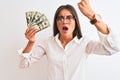 Beautiful businesswoman wearing glasses holding dollars over isolated white background annoyed and frustrated shouting with anger, Royalty Free Stock Photo