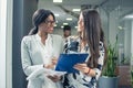 Beautiful businesswomen discussing contract together in office. Royalty Free Stock Photo