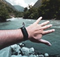 Beautiful butterfly on the smart watch on the hand against the background of the river and green nature