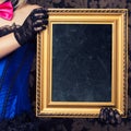 beautiful cabaret woman posing with golden frame against retro w Royalty Free Stock Photo