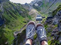 Beautiful cable car ride, sneakers on the background of a mountain landscape, first-person photo.