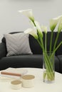 Beautiful calla lily flowers in glass vase, boxes and books on white table at home Royalty Free Stock Photo