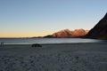 Beautiful calm blue waves hitting white frozen sandy beach in late autumn in the arctic circle with deep mountain and open sea