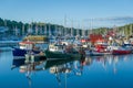 Beautiful calm day in Tarbert harbor. Colorful loal`s boats and water reflections.