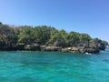 Beautiful calm blue green ocean along the rocks with vegetation Royalty Free Stock Photo