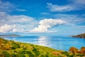 Beautiful calm sea, meadow field, clouds, sky and island landscape of a holiday place