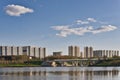 Beautiful calm urban cityscape at summer day. View on lake, park, road bridge, residential buildigs and blue sky with Royalty Free Stock Photo