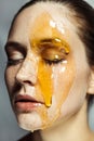 Beautiful calm young woman with freckles, doing cosmetology procedures, applying honey on her face. Royalty Free Stock Photo