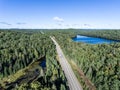 Beautiful Canada camper bus driving on road endless pine tree forest with lakes moor land aerial view travel background Royalty Free Stock Photo