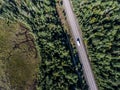 Beautiful Canada camper bus driving on road endless pine tree forest with lakes moor land aerial view travel background Royalty Free Stock Photo