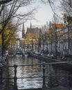 A beautiful canal scene in Amsterdam in autumn, with the iconic twin spires of De Krijtberg church. Royalty Free Stock Photo