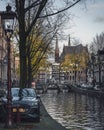 A beautiful canal scene in Amsterdam in autumn, with the iconic twin spires of De Krijtberg church. Royalty Free Stock Photo