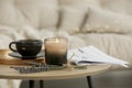 Beautiful candle, lavender, newspaper and cup on round wooden table in living room Royalty Free Stock Photo