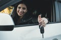 Beautiful car driver woman smiling showing new car keys and car. Caucasian girl sitting in automobile, smiling and