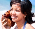 Beautiful caribbean woman holding a conch shell