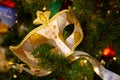 Beautiful carnival mask hanging on the Christmas tree in the background of bright Christmass decorations Royalty Free Stock Photo