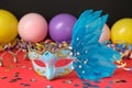 Beautiful carnival mask and party decor on red table, closeup Royalty Free Stock Photo