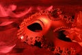 Beautiful carnival mask on table in red light, closeup Royalty Free Stock Photo