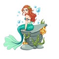 Beautiful cartoon mermaid with curly red hair and green fish tail sitting on sea rock with seaweed