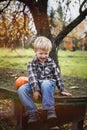 Beautiful casual blond child sitting outdoor on table and laughing. Autumn Royalty Free Stock Photo