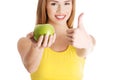 Beautiful casual caucasian woman holding fresh green apple.