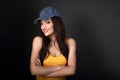 Beautiful casual smiling woman in blue baseball cap and yellow t Royalty Free Stock Photo
