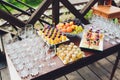 Beautiful catering banquet buffet table decorated in rustic style in the garden. Different snacks, sandwiches and Royalty Free Stock Photo