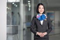 Beautiful Caucasian airline staff woman standing indoor in airport terminal building. The girl wearing airliner uniform waiting fo Royalty Free Stock Photo