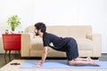 Beautiful caucasian bearded man in black clothes on blue yogamat doing cow pose