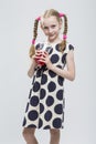 Beautiful Caucasian Blond Girl With Pigtails Posing in Polka Dot Dress Against White.