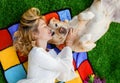 Beautiful caucasian blonde girl lying with a white Labrador dog in the garden Royalty Free Stock Photo