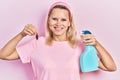 Beautiful caucasian blonde woman holding cockroach and pesticide sprayer smiling with a happy and cool smile on face Royalty Free Stock Photo