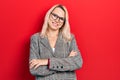 Beautiful caucasian blonde woman wearing business jacket and glasses happy face smiling with crossed arms looking at the camera Royalty Free Stock Photo