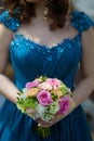 Beautiful Caucasian bridesmaid wearing a popping blue tulle dress and holding an elegant bridal bouquet Royalty Free Stock Photo