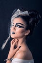 Caucasian Brunette with Half Face Painted with White and Half Graphic Black Make-up, Scratching Her Neck, on Black Background. Royalty Free Stock Photo