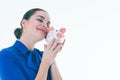 Beautiful Caucasian brunette woman listens to the sound of coinsin a piggybank and dreams. Royalty Free Stock Photo