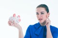 Beautiful Caucasian brunette woman listens to the sound of coinsin a piggybank and dreams. Royalty Free Stock Photo