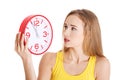 Beautiful caucasian casual woman holding red clock. Royalty Free Stock Photo