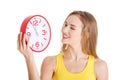 Beautiful caucasian casual woman holding red clock. Royalty Free Stock Photo