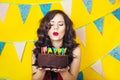 Beautiful caucasian girl blowing candles on her cake. Celebration and party. Having fun. Young pretty woman in red dress and birth Royalty Free Stock Photo