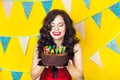 Beautiful caucasian girl blowing candles on her cake. Celebration and party. Having fun. Young pretty woman in red dress and birth Royalty Free Stock Photo