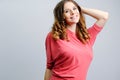 Portrait of a beautiful caucasian girl with brown wavy hair. Beauty lady, elegant young woman smiling, grey wall on background. Royalty Free Stock Photo