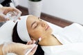 Beauty master applies a rejuvenating mask to the clients face