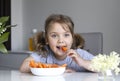 Beautiful caucasian girl eating carrots. Kid\'s healthy nutrition concept. Little child eating fresh vegetables Royalty Free Stock Photo