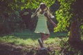 Little lovely girl in yellow dress dancing in the grass by the river Royalty Free Stock Photo