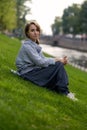 Beautiful caucasian girl sits on green grass