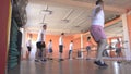 Beautiful caucasian girl trainer shows men exercises for weight loss and health in a modern fitness center, group