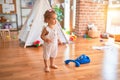 Beautiful caucasian infant playing with toys at colorful playroom